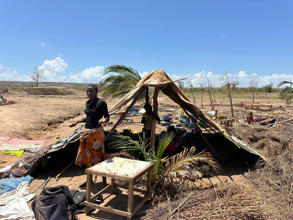 A woman stands in front of a shelter.