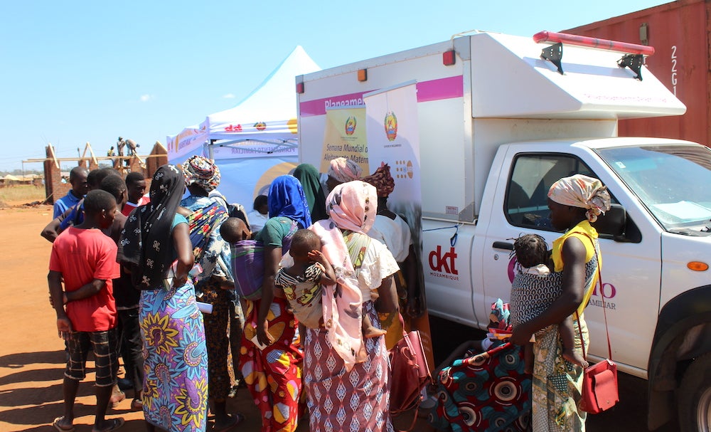 a group of people standing next to a truck