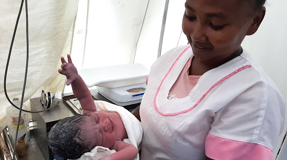 Midwife Marie Nancy Christiane with baby Noelia, born in a tent provided by UNFPA as a temporary maternity ward, after the refer