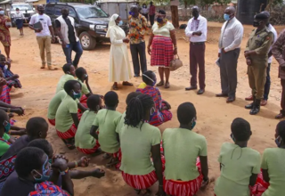 A delegation of  state ministers and district leaders speak with girls at the Kalas primary school in Amudat.