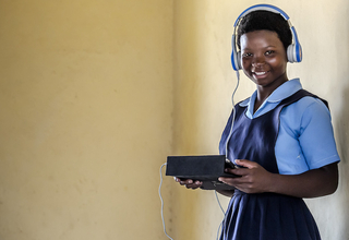 A girl from Malawi holding a tablet.