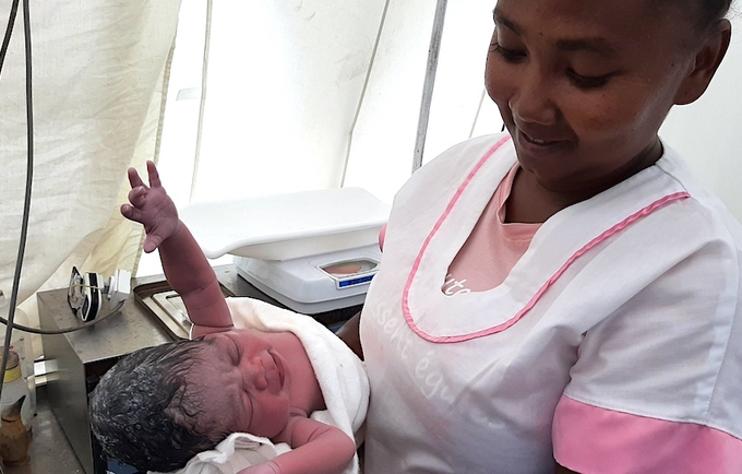 Midwife Marie Nancy Christiane with baby Noelia, born in a tent provided by UNFPA as a temporary maternity ward, after the refer