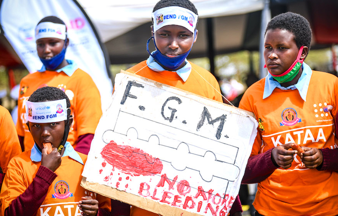 Students from Kisima Primary School hold placards calling for an end to FGM.