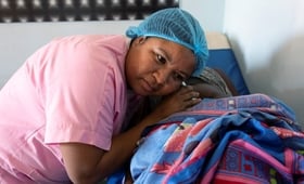 Nurse Sitraka examines a pregnant woman's abdomen and listens to a pregnant woman's abdomen through a pinard stethoscope.