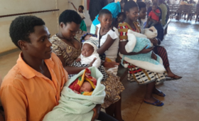 A man waiting in a queue to immunize their baby at Bududa Hospital 