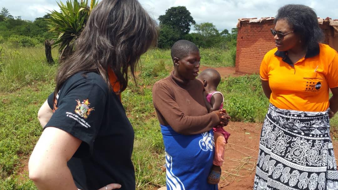 UNFPA Zimbabwe colleagues Rose Katumba and Verena Bruno listen to a pregnant survivor of Cyclone Idai in Chipinge as she narrates how her antenatal care records and medication were swept away by the floods. © UNFPA Zimbabwe