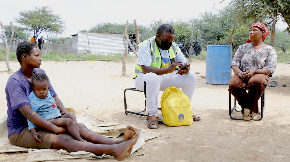 Census enumerator Sakarea Lepono explaining the importance of being counted to Segolame Bolosaka and her sister.