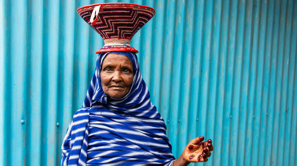 Ugosa Hassan with the basket she weaved at the Women and Girls’ Friendly Space in Chinaksen, Oromia region.