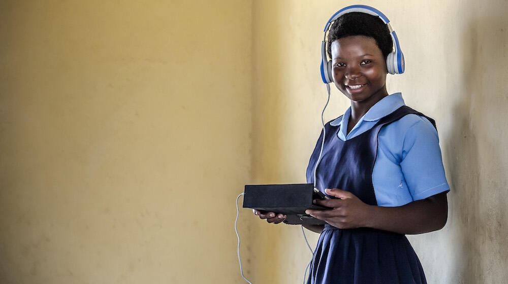 A girl from Malawi holding a tablet.